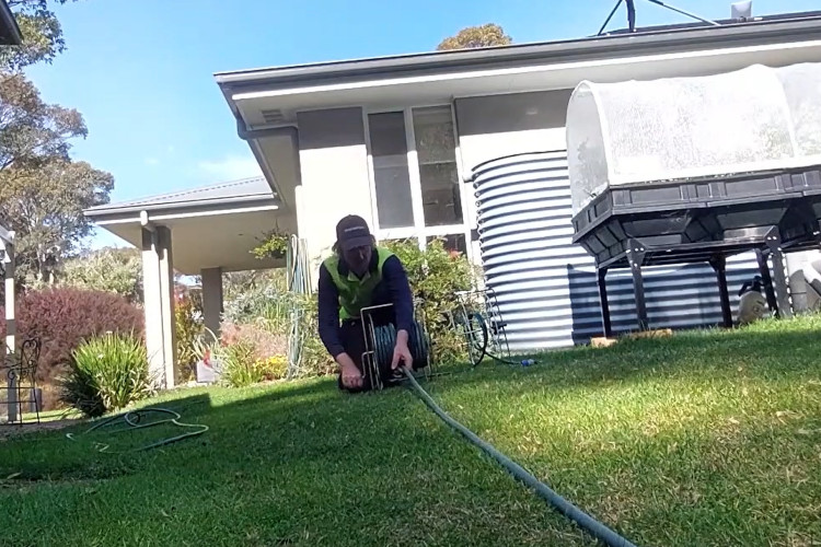 
Wrapping up his daily work, the ulladulla downpipe cleaner is neatly storing his hose.