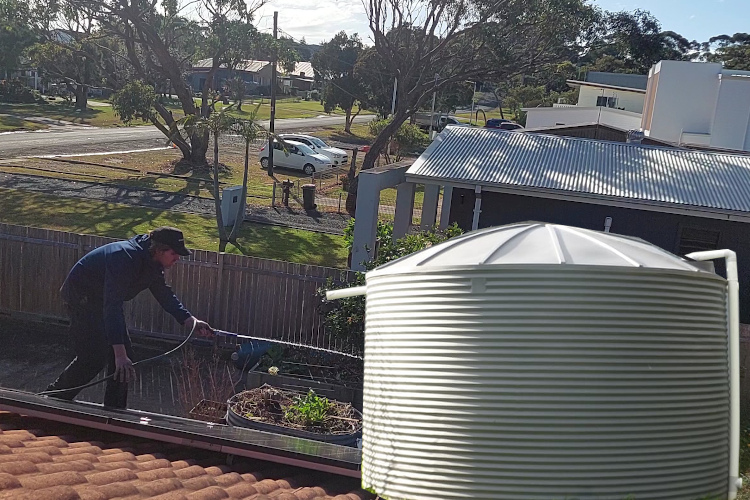 
ulladulla Gutter Cleaner Flushes Gutters on Rainwater-Reliant Site